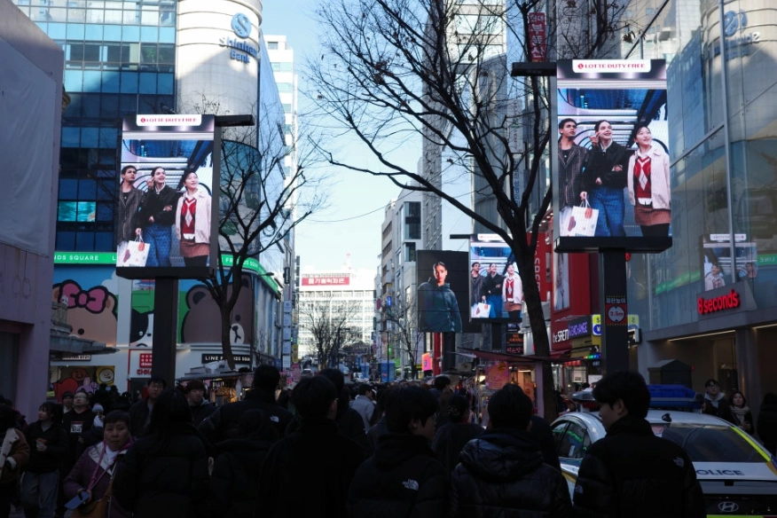 Crowds walking between shops and digital displays in Myeongdong, Seoul