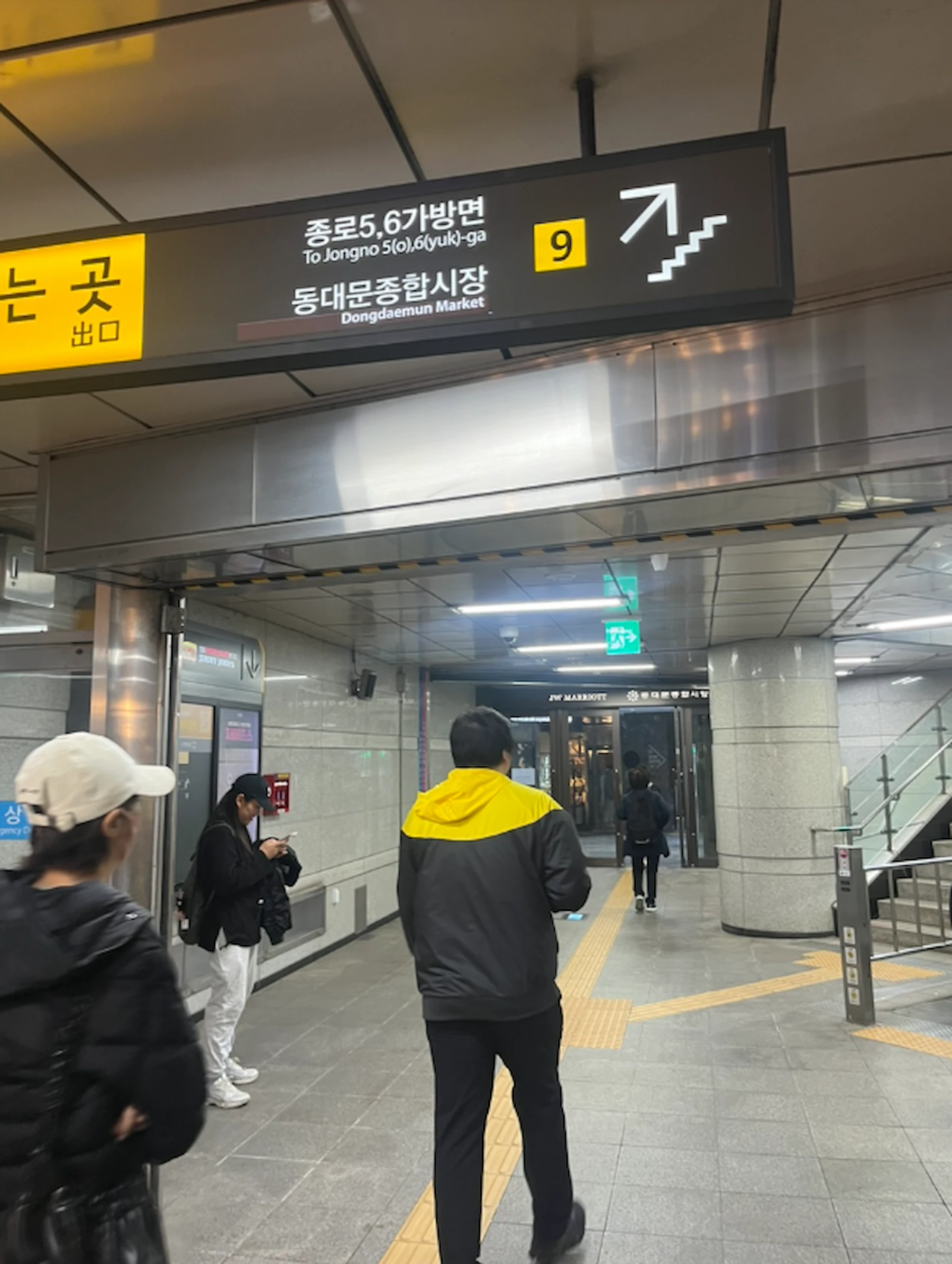 Dongdaemun Station Exit 9 sign pointing toward Dongdaemun Shopping Complex