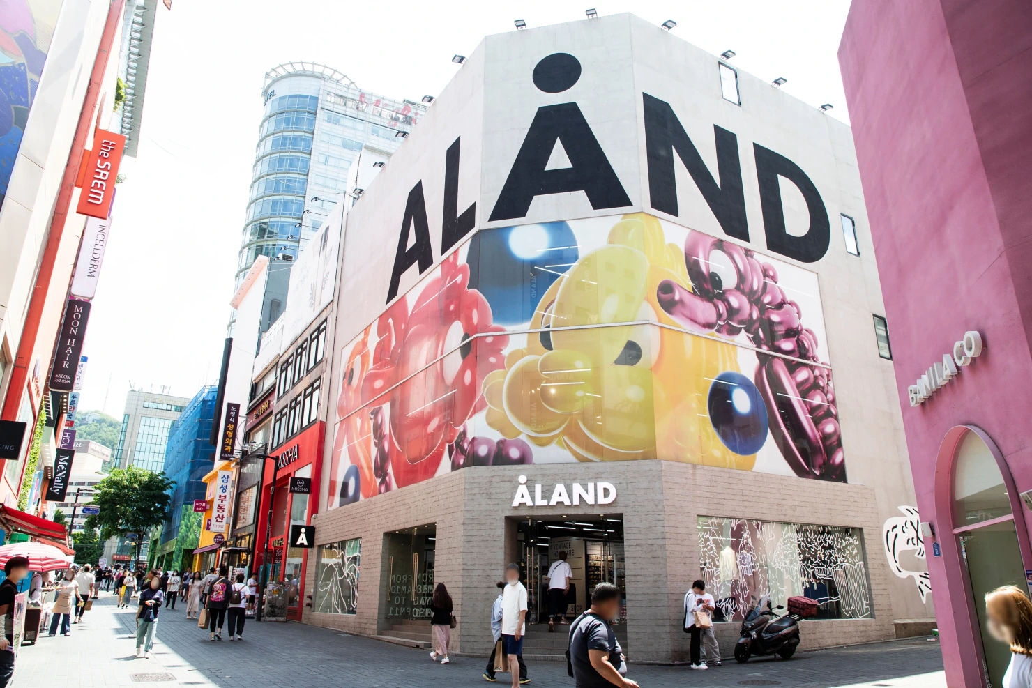 ALAND and neighboring storefronts along a pedestrian shopping street in Myeongdong.