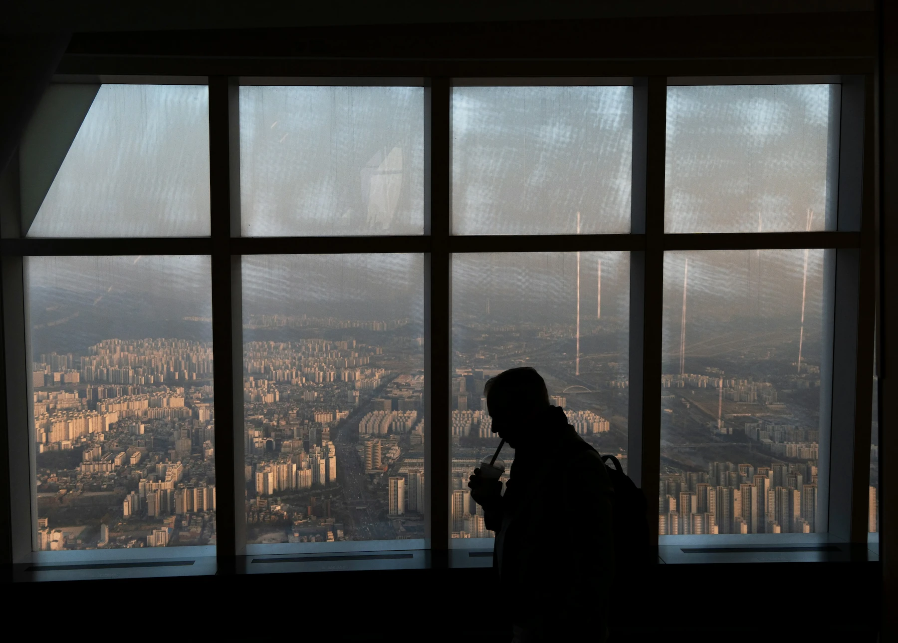 Visitor looking over Seoul from inside the Seoul Sky observatory